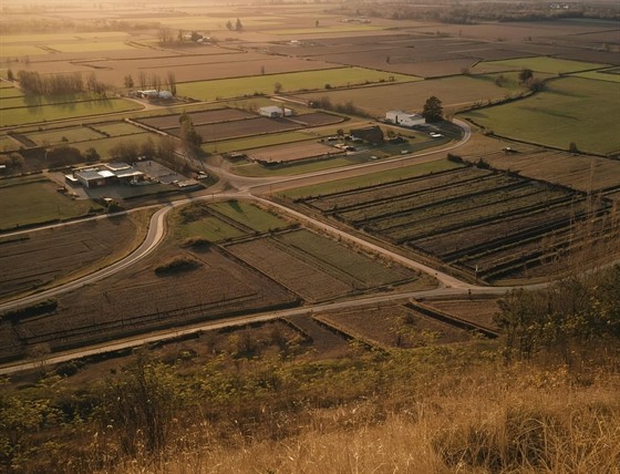 Aerial view of agricultural fields and farm buildings at golden hour
