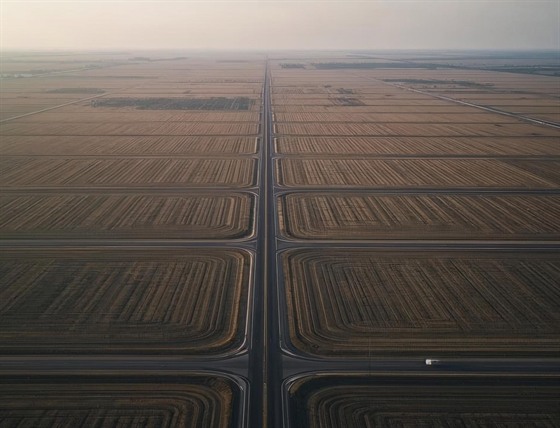Aerial view of cross-shaped roads through large agricultural fields